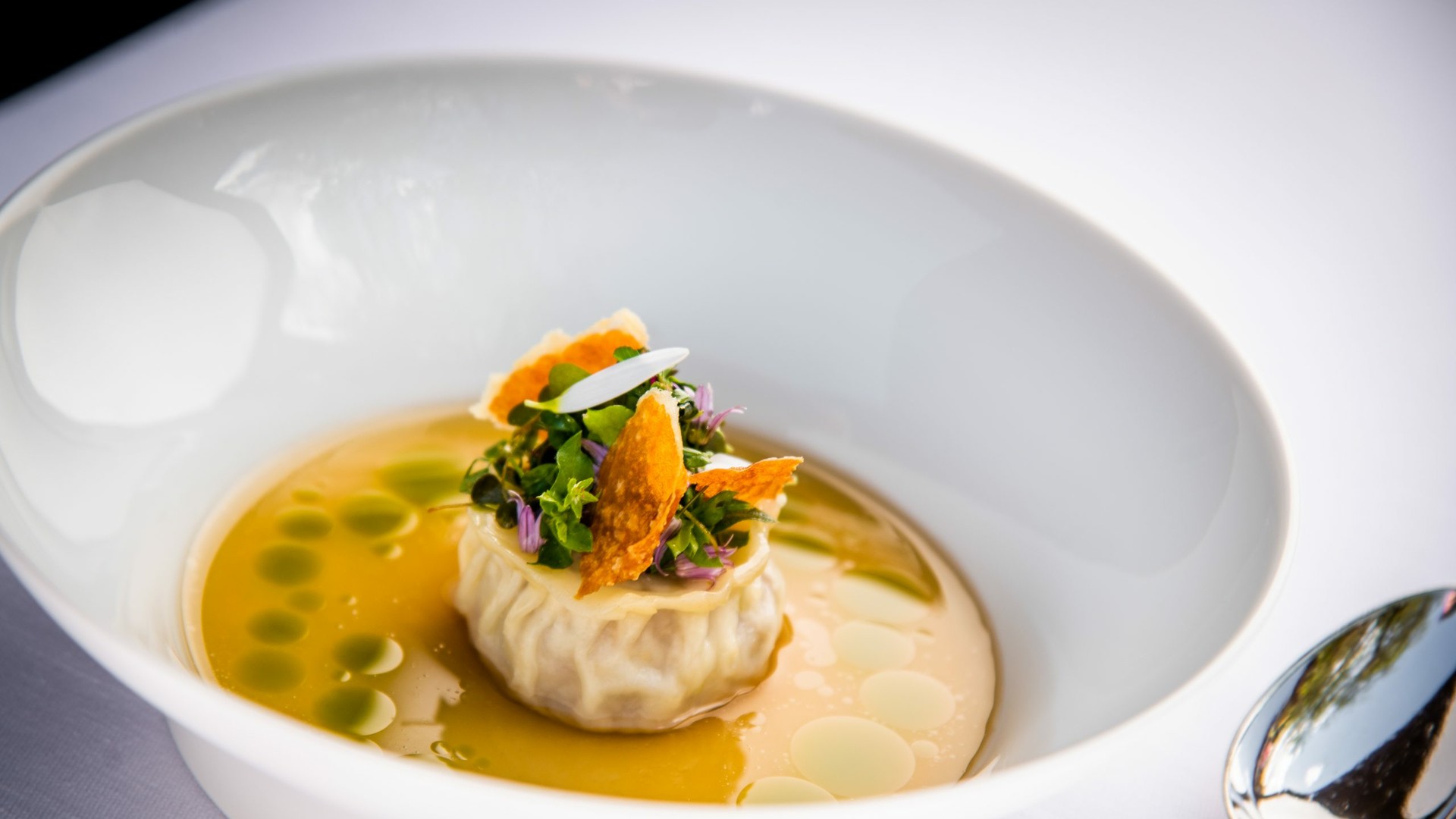 Raviolo vom Bierschwein, Piora-Alp Rohschinken, Senfsaat, Bergkräuter.